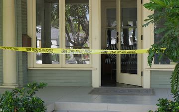Crime scene yellow tape stretched across home front porch